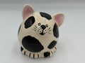 Black and white pudgy ceramic cat coin bank with pink ears and painted whiskers