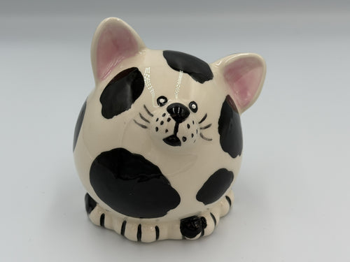 Black and white pudgy ceramic cat coin bank with pink ears and painted whiskers