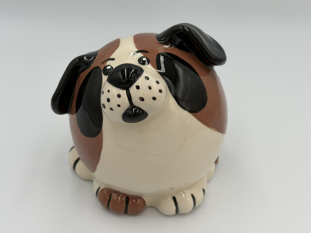 Round cream ceramic dog bank with brown and black patches and floppy black ears
