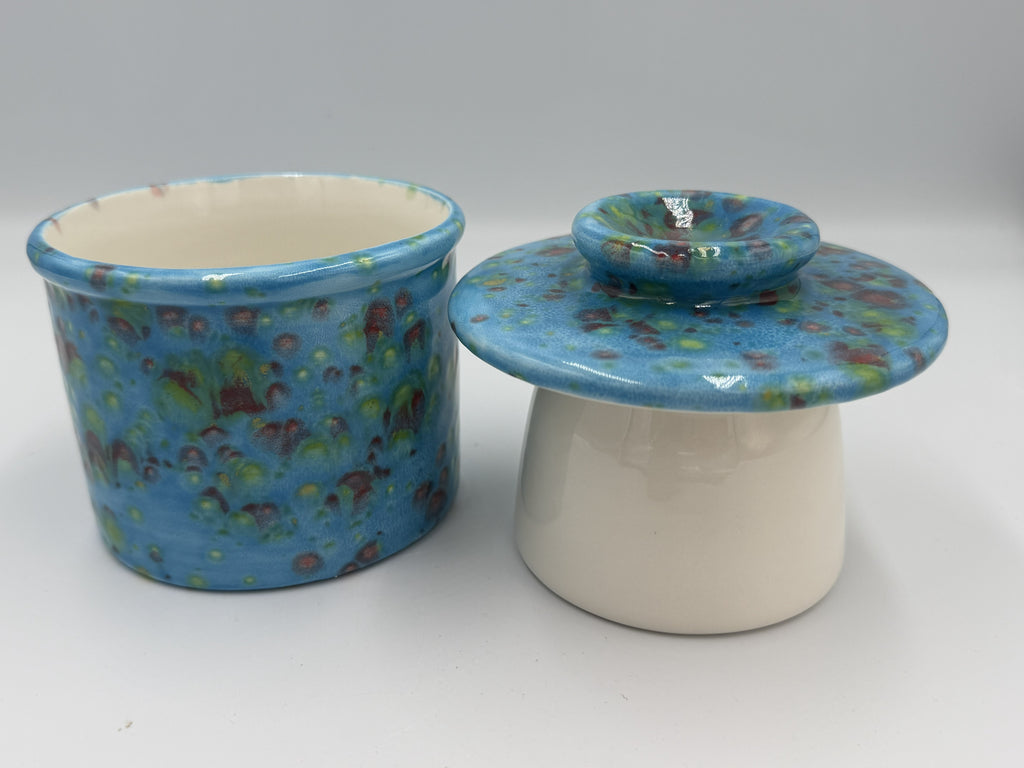 Sky blue speckled ceramic butter bell base and bell-shaped lid side by side