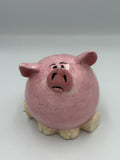Round dark pink speckled ceramic pig bank with glossy snout, pink ears, and cream hooves