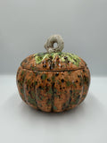 Caramel-orange speckled ceramic harvest pumpkin jar with green leafy lid and cream curly stem