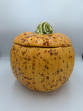 Large golden orange speckled ceramic pumpkin jar with lid and green stem