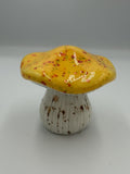 Ceramic mushroom with glossy yellow speckled cap and ribbed cream stem
